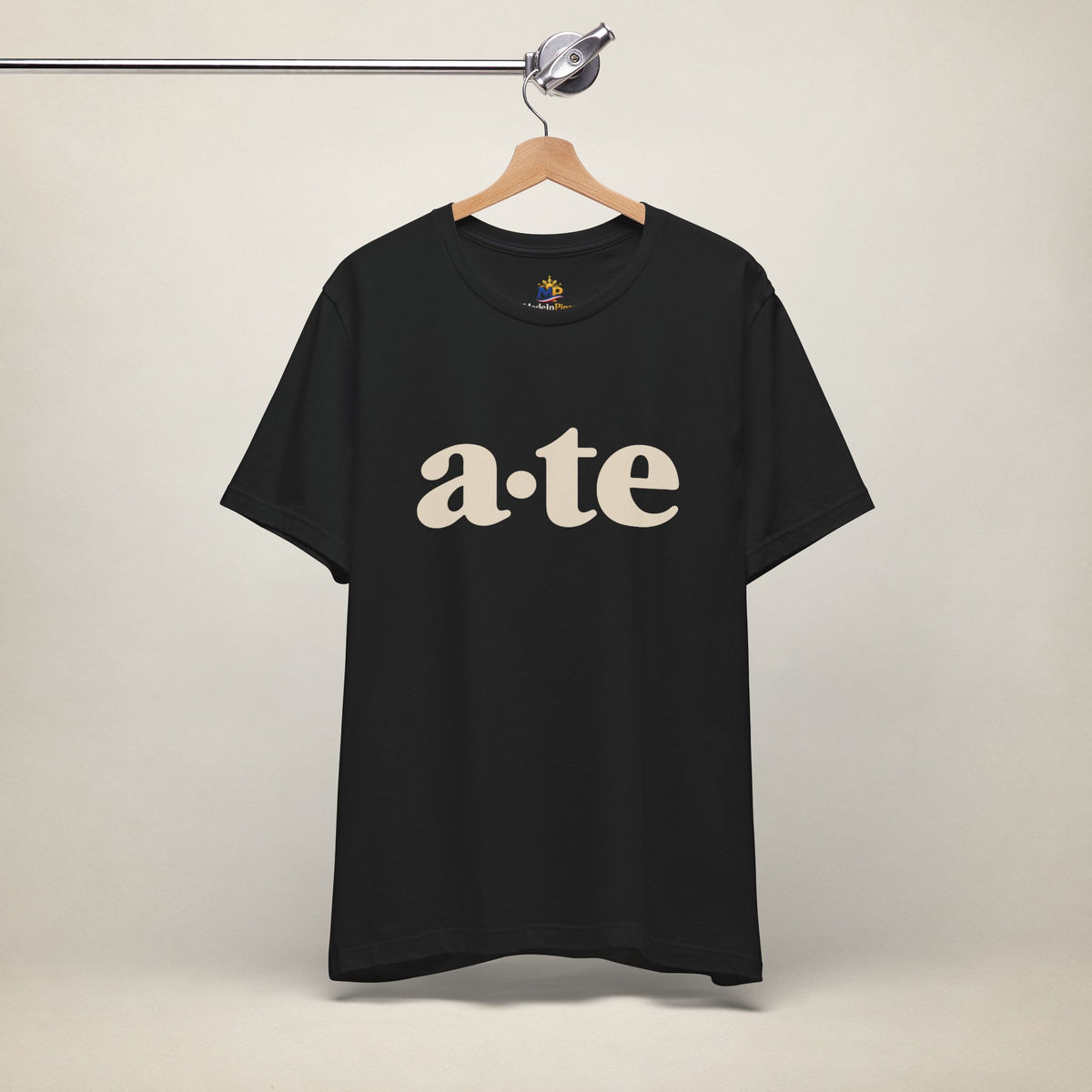 Black MadeInPinas ATE Filipino T-shirt on a hanger, front view with minimalist a·te lettering.