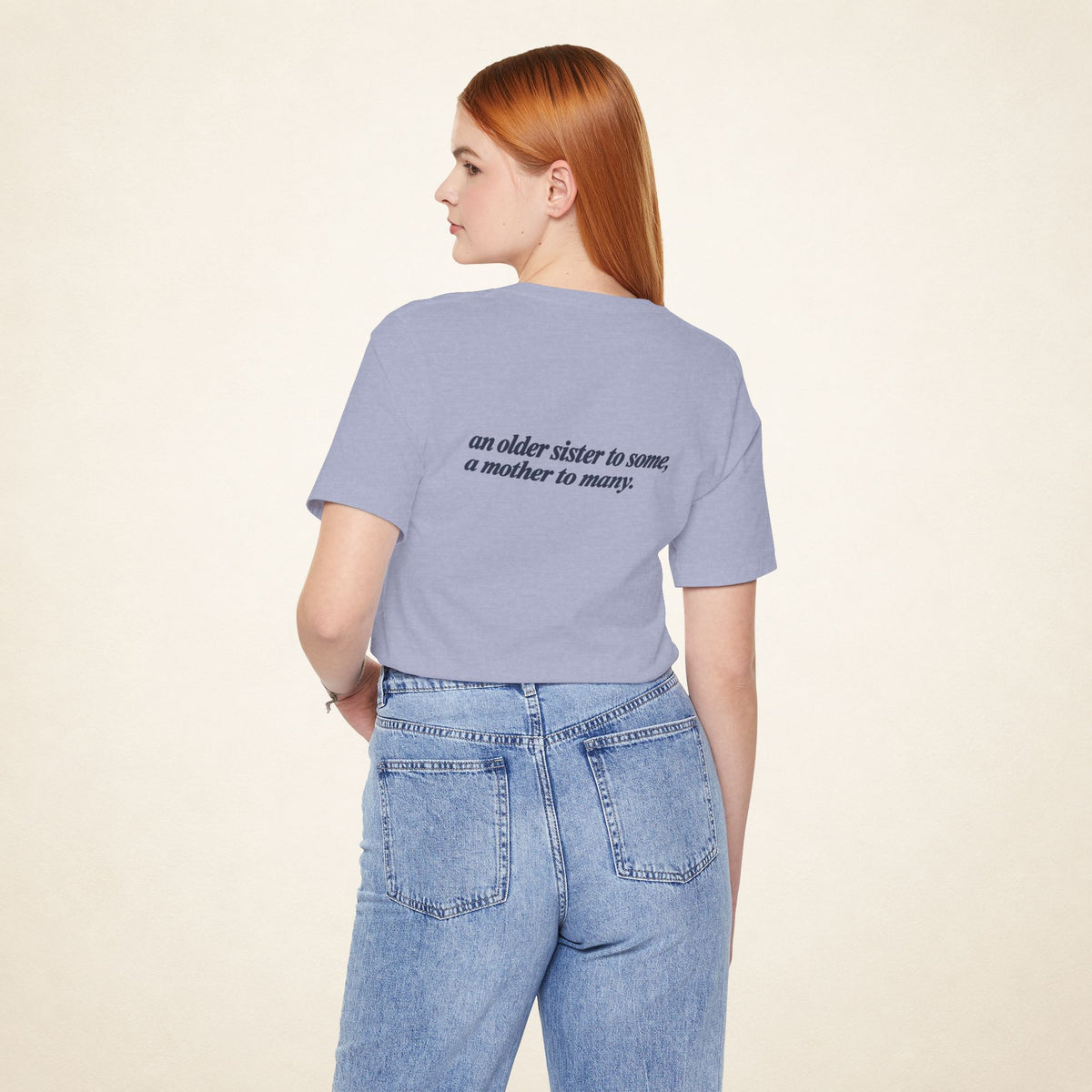 Model wearing the Heather Blue ATE Filipino T-shirt from behind, with the message “an older sister to some, a mother to many.”