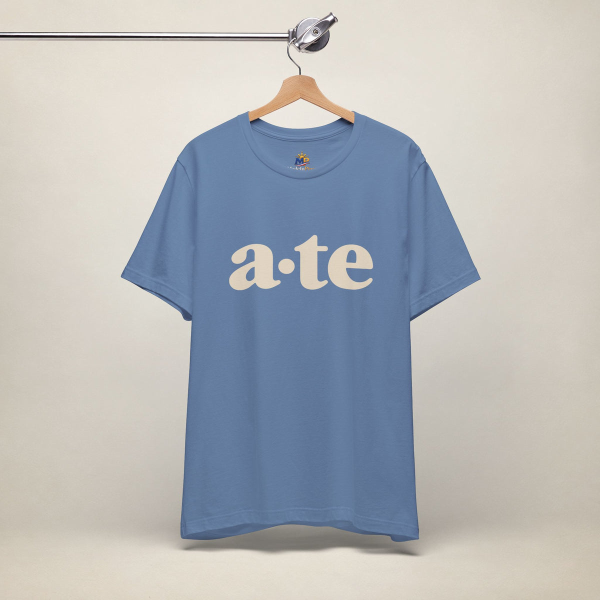 Lavender Blue MadeInPinas ATE Filipino T-shirt on a hanger, front view with minimalist a·te lettering.