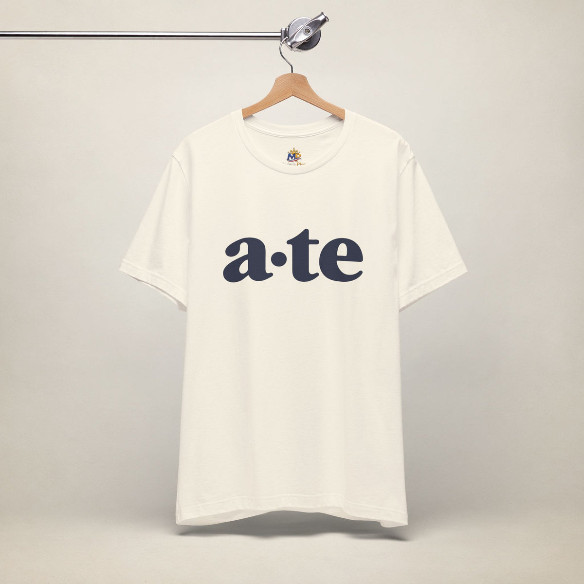 Natural MadeInPinas ATE Filipino T-shirt on a hanger, front view with minimalist a·te lettering.