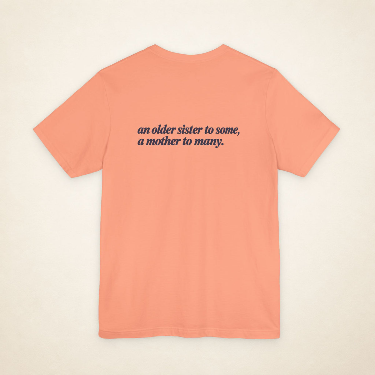 Sunset ATE Filipino T-shirt, flat-lay back view with the message “an older sister to some, a mother to many.”