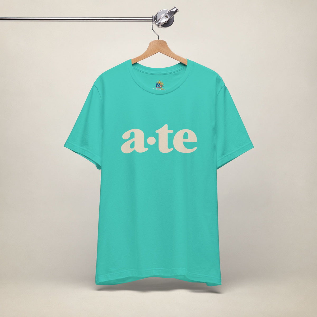 Teal MadeInPinas ATE Filipino T-shirt on a hanger, front view with minimalist a·te lettering.