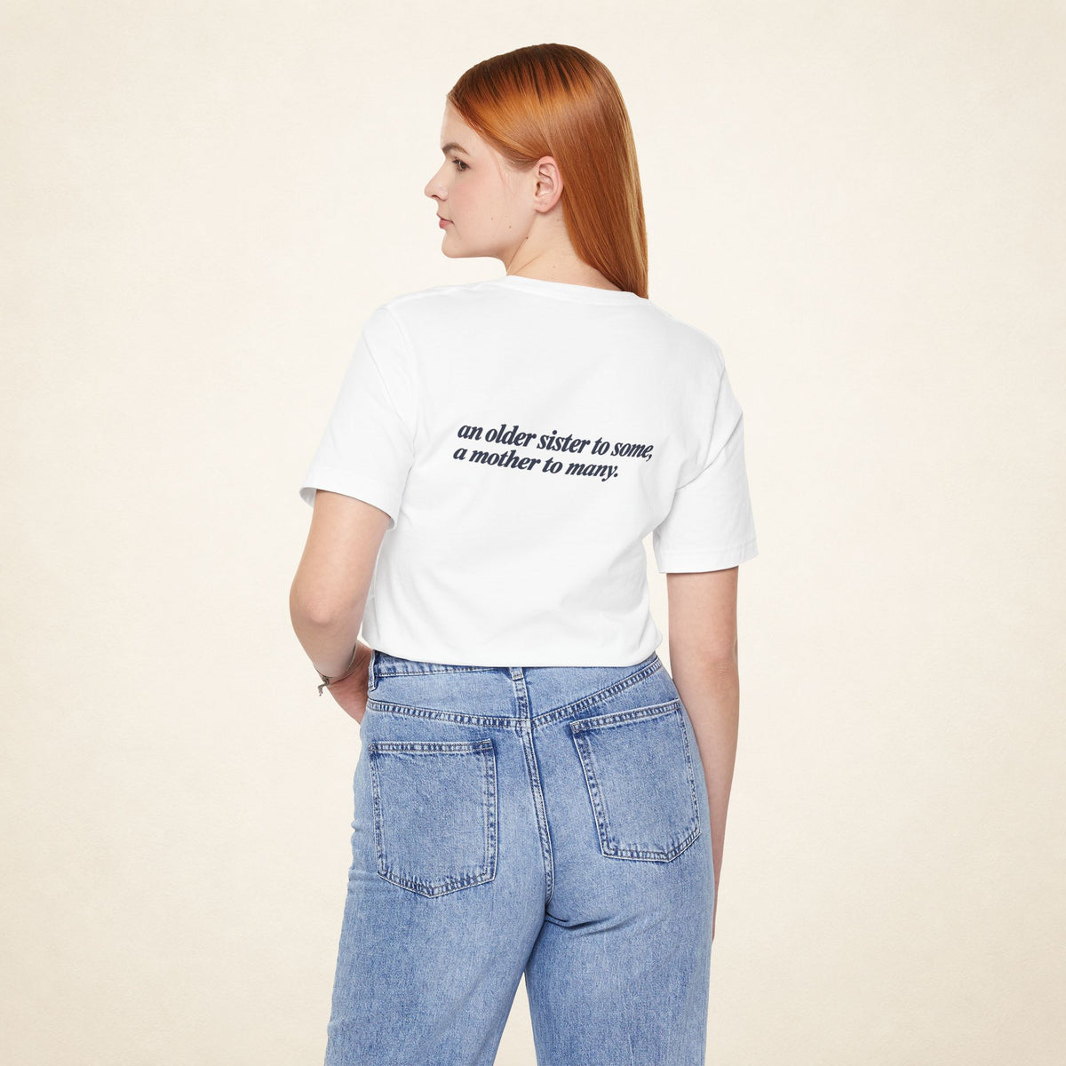 Model wearing the White ATE Filipino T-shirt from behind, with the message “an older sister to some, a mother to many.”