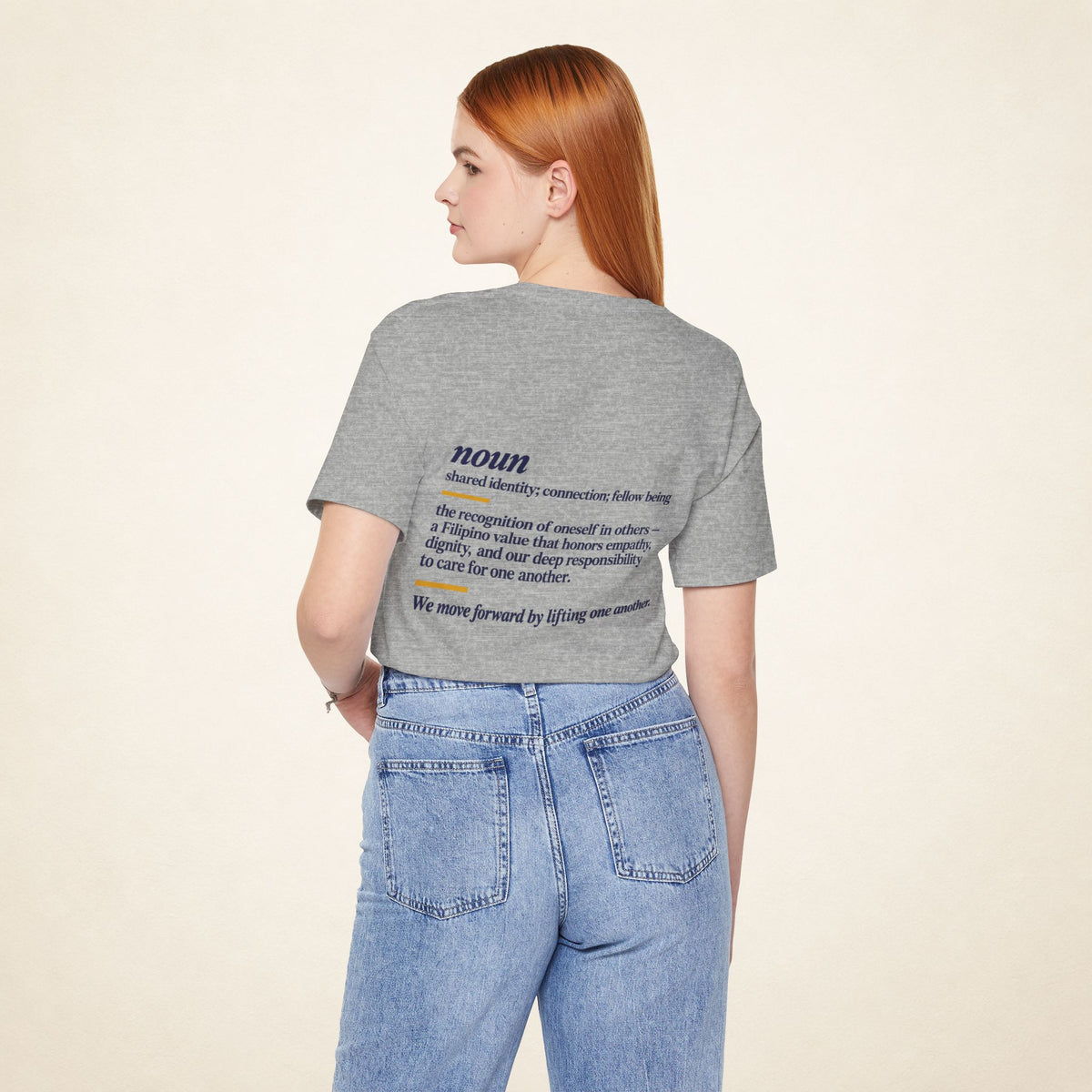 Model wearing the Athletic Heather KAPWA T-shirt from behind, showing the shared humanity back design.