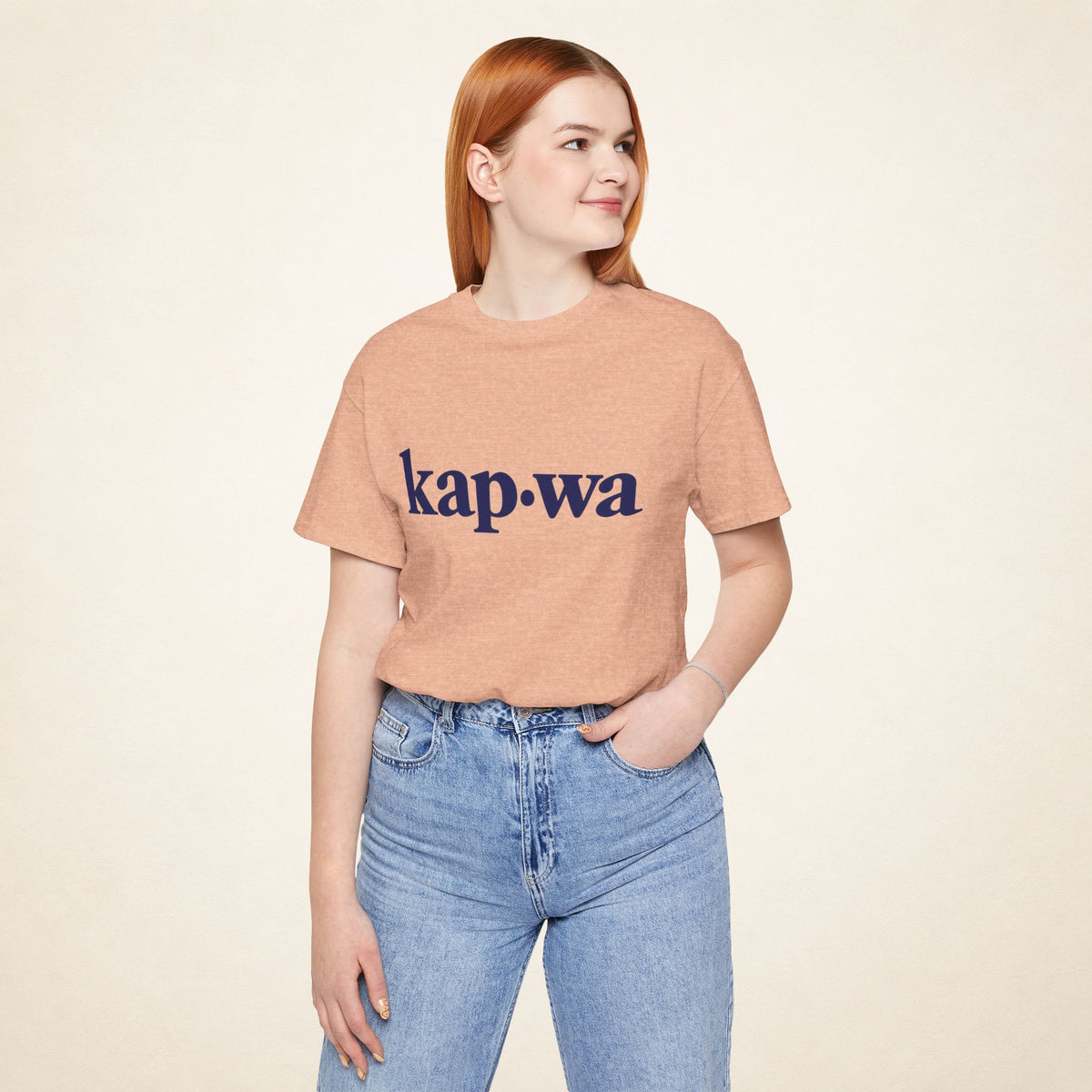 Model wearing the Heather Peach KAPWA Filipino graphic tee, front view with kap·wa typography.
