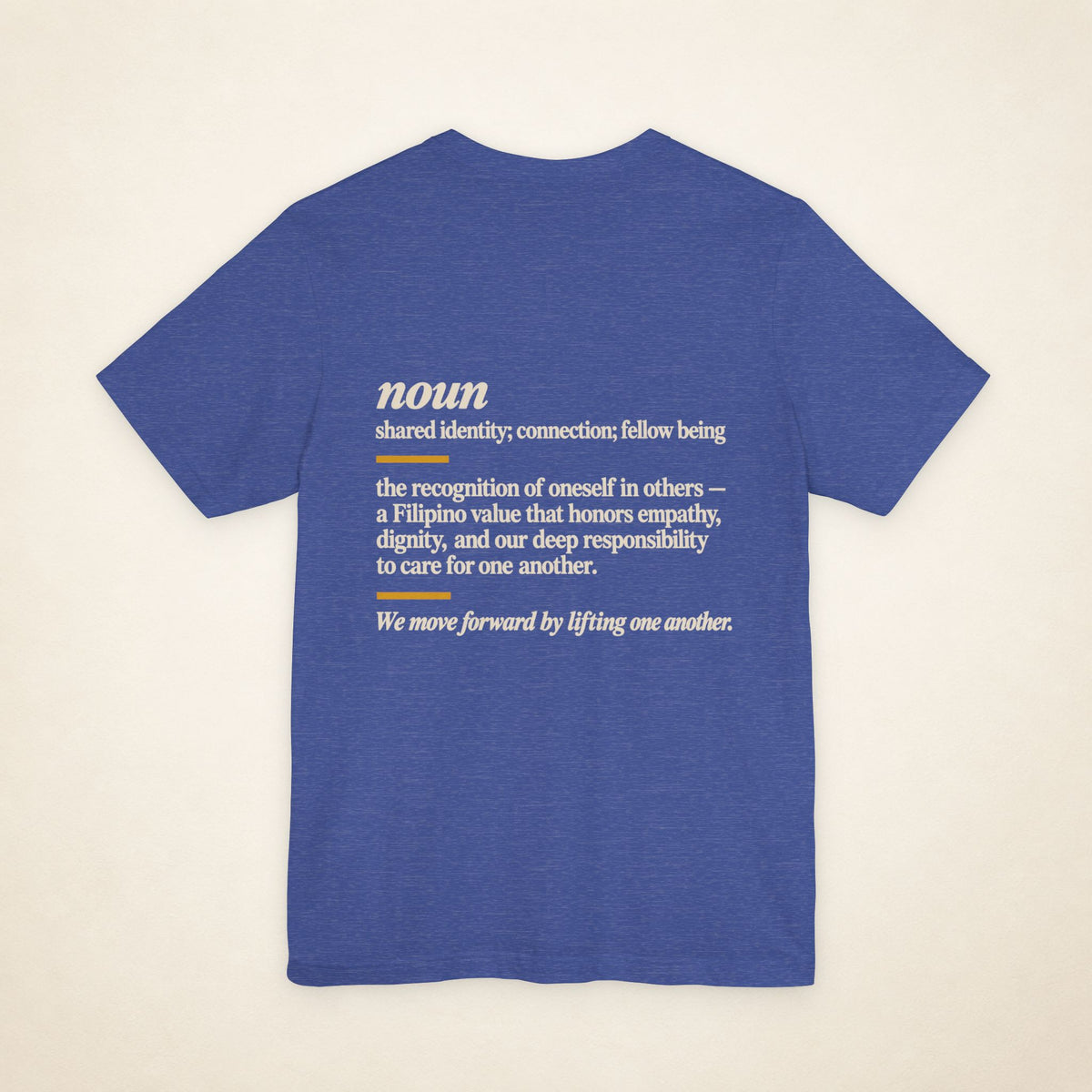 Back of the Heather True Royal KAPWA graphic T-shirt showing the dictionary-inspired shared identity message.