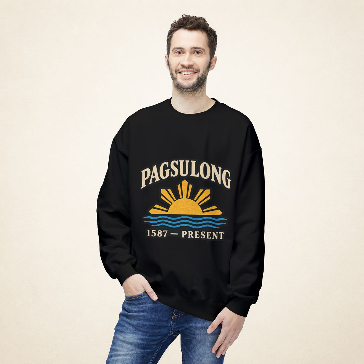 Male model wearing the black PAGSULONG Filipino American heritage sweatshirt with a Philippine sun and waves graphic on the front, styled with blue jeans.